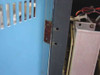 UPS cabinet door hinge area showing missing top hinge — two empty mounting holes with surface rust on hinge plate