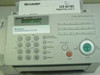 Sharp UX-B700 front control panel close-up showing LCD displaying DOCUMENT JAMMED, numeric keypad, function buttons, and Business Communication Center label