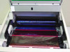 Tektronix Phaser 440 internal ribbon compartment open showing cyan and magenta thermal transfer ribbon rolls with visible ribbon damage