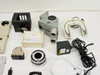 Close-up grouping showing black filter cube, gray optical head with dual ports, white ring light illuminators with cables, small power supply, and a labeled filter box