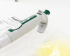 Close-up of Hamilton SoftGrip pipette showing green top plunger button, white body with Hamilton branding, 25µL label, and ejector arm detail