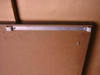 Herman Miller Action Office II work surface – close-up of aluminum mounting bracket rail on underside showing bracket ends and fastener holes