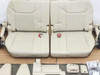 Lexus LX570 3rd row seat assembly — top-down view of two-section beige leather seat cushions with red belt buckles, hinge covers, and hardware bags