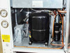 Motivair MPC-FC-0500 — interior compressor bay showing large black compressor, copper refrigerant piping, and refrigerant accumulator/receiver vessel