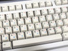 Close-up of dual-language keyboard keycaps — English characters with Traditional Chinese (Bopomofo) secondary legends in red and blue