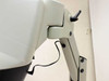Close-up of Mantis articulating arm hinge joint showing tension adjustment, pivot mechanism, and power cable routing; scuffing visible on arm surfaces