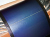 Close-up of Uni-Solar PVL-136 flexible amorphous thin-film solar panel surface showing triple-junction cell laminate and black frame border