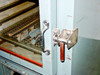 Hotpack 733 door latch mechanism close-up — cam-action metal latch with red and wood handle