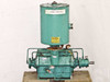 Kinney KDH-130 high vacuum pump – full front view showing teal two-stage pump body with cylindrical oil separator on top and shaft end visible at right, mounted on wooden pallet