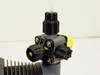 LMI Milton Roy AA971-358SI liquid end valve assembly — left angle view showing check valve body and yellow priming vent knob with chemical residue
