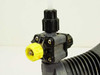 LMI Milton Roy AA971-358SI liquid end valve assembly — front angle view showing check valve manifold and yellow priming vent knob with chemical deposits
