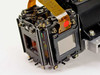 Close-up of LCD projector prism block showing two LCD panel windows with iridescent coatings and flat flex ribbon cables attached