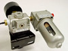 TMC Micro-g NAF2000 NAR2000 assembly rear/side view — SMC NAR2000 air regulator with black adjustment knob and mounting bracket left, SMC air filter with transparent bowl and red button right, both labeled Made in Japan