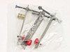 Sealed plastic bag containing TMC vibration isolation table mounting hardware — two leveling rods with red adjustment knobs, brass fitting, and screws with blue heads