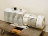 Leybold-Heraeus D60AC Trivac rotary vane vacuum pump – front-left view showing finned white pump body with two top ports and coupled three-phase motor on wheeled base