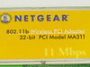 Close-up of Netgear MA311 front label reading '802.11b Wireless PCI Adapter, 32-bit PCI Model MA311, 11 Mbps'