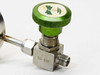 Close-up of Nupro SS-4H stainless steel angle needle valve body showing SS-4H stamping, green knurled handle, and compression fitting outlet