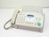 Sharp UX-100 plain paper fax machine front view showing handset, keypad, LCD display, and paper feed tray