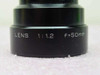 Elmo projection lens barrel close-up showing engraved LENS 1:1.2 f=50mm specification markings