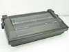 Commodore DPS-1101 Daisy Wheel Printer – front three-quarter view showing dark plastic housing and paper guide under clear cover