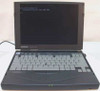 Compaq Armada 3500 laptop open, front view — screen displaying MS-DOS prompt, full keyboard visible, three green indicator LEDs lit on front edge