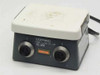 Corning PC-351 Hot Plate Magnetic Stirrer front view showing dual control knobs, orange indicator light, and white ceramic top plate with surface soiling
