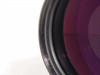 Close-up of lower-left quadrant of Nikon Printing-Nikkor 105mm f/2.8 front element showing magenta coating and filter ring threads