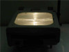 Dukane 663 overhead projector powered on with Fresnel stage lens illuminated brightly — low-light view showing lamp output