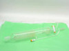 Glass spiral coil heat exchanger with 500mL graduated cylinder and separate small glass piece with orange-capped stopcock — full set overview on green surface