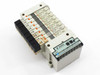 SMC EX120-SSH1 serial interface unit with 8x VQ1100-5 solenoid valves mounted on manifold — angled front-right view showing orange indicator flags and solenoid coil bodies