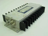 Avantek APG-2052M GaAs FET Amplifier – three-quarter front view showing aluminum housing, finned heatsink, and SMA input/output connectors on left end
