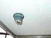 Close-up of NPT outlet fitting on tank exterior – threaded gray fitting with worn thread tape visible
