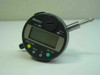 Mitutoyo ID-C112E digital dial indicator front view showing LCD display, ZERO/ABS, PRESET, TOL, and ON/OFF buttons with yellow and green indicator lights