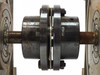Close-up of shaft coupling assembly connecting the two Sandex 7FU indexing drives — shows coupling hub, fasteners, and drive shafts
