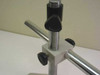 Boom stand column detail showing vertical post, horizontal arm clamp, height lock knob, and base plate