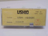 Ushio USH-102DH mercury arc lamp label showing model number, serial number 5120014, and Ushio Inc Tokyo Japan — top view of plastic case