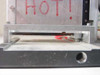 Close-up side view of heat sealing head showing narrow 1/8-inch serrated sealing element strip between upper jaw and lower platen