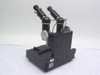 Comparison microscope right rear three-quarter view — both optical tubes visible from behind, side micrometer adjustments, sticker on base