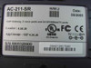 SunRocket AC-211-SR VoIP Gateway — bottom label showing model number, H/W Rev J, manufacture date 08/2005, SIP firmware version, UL/FCC/CE certifications, and 5V 2A power rating