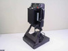 Polaroid Laminex LX400 photo ID camera on desktop stand — right side view showing film pack door and power cord