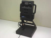 Polaroid Laminex LX400 4-lens photo ID camera mounted on black desktop stand — front/left three-quarter view showing four lens apertures and Laminex badge
