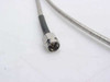 Close-up of SMA male connector on semi-rigid coaxial cable showing center pin and threaded coupling nut with braided sheath transition
