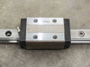 UG9K83 pillow block carriage close-up showing recirculating ball bearing block and grease fitting on rail