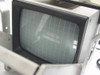 Sanyo VM 4509 B/W CRT monitor screen close-up inside Tekskil teleprompter — showing curved CRT display with grid-line safety screen