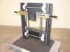 Gravity hoist faceplate mount dual chain counterbalance assembly – front three-quarter view showing THK linear slide, dual roller chains, black steel frame, and handle grips