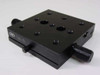 Newport TSX-1D dovetail linear stage – 3/4 angled top view showing black anodized aluminum platform with threaded mounting holes, dual adjustment knobs, and TSX-1D model label