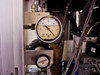 Vacuum pressure gauge reading approximately 0–30 in Hg range with Fairchild regulator below it – mounted in pneumatic bay