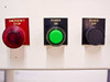 Control panel button cluster – Emergency Stop (red mushroom), Power On (green illuminated), and Power Off (black) buttons