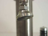 Close-up of the punch ram nose/tip — mushroom-shaped stainless punch tool at bottom of vertical ram stroke