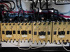 Close-up of five Allen-Bradley yellow motor starter contactors mounted in a row at bottom of enclosure, wired with black and white leads